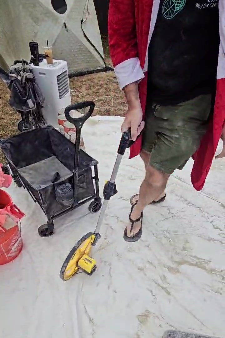Griff walking the measuring wheel, flag bucket beside