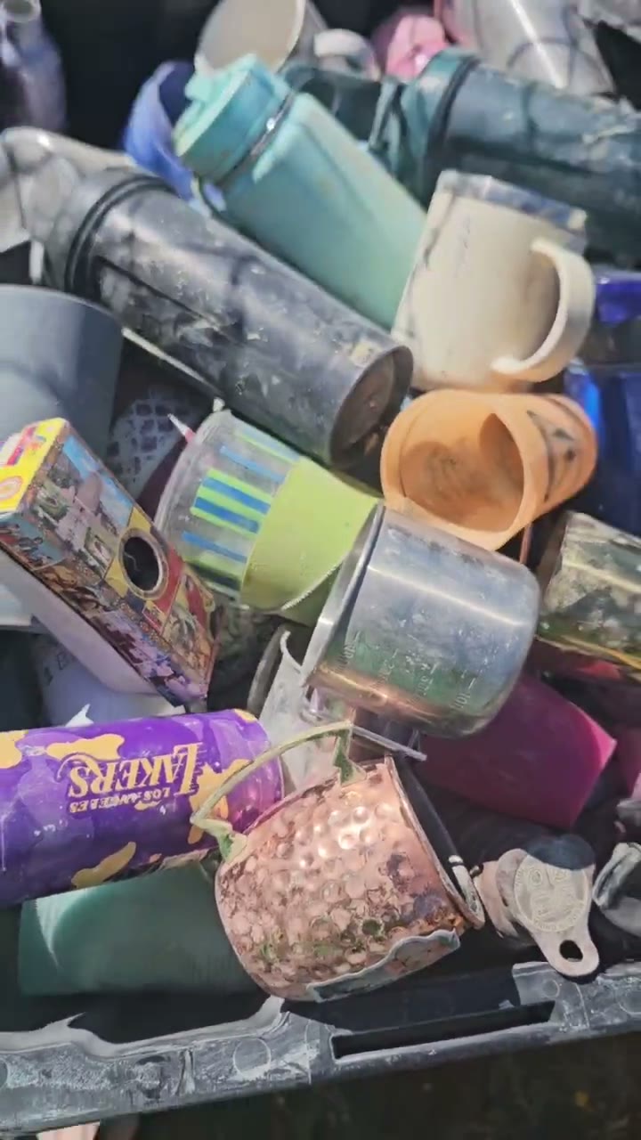 A crate piled with mugs, bottles and random camp stuff