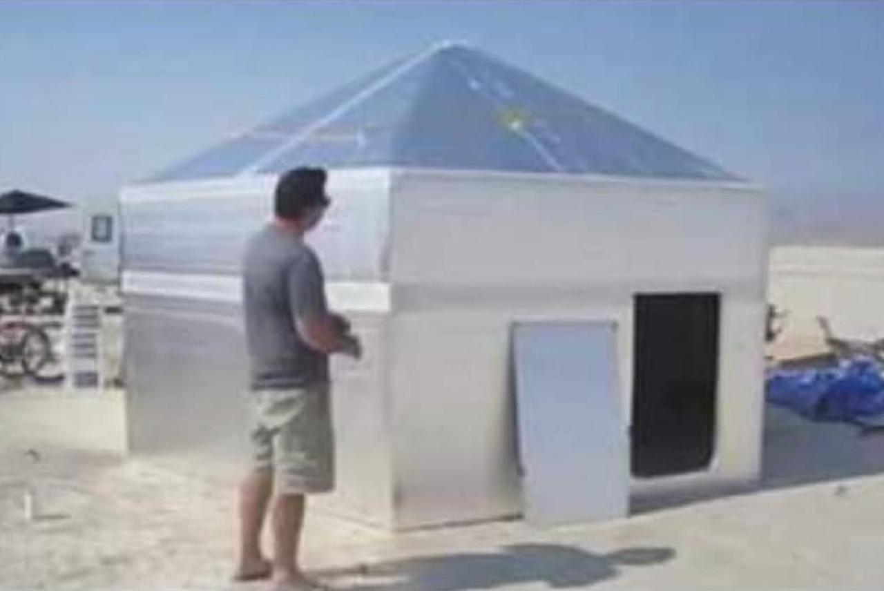 The hexayurt set up on playa, silver panels and pyramid roof